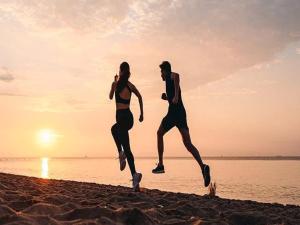 un paio di persone che corrono sulla spiaggia di Comfortable holiday houses near the sea, Rewal a Rewal
