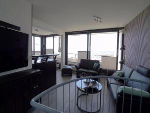 a living room with a couch and a television at Penthouse Wohnung direkt am Nodseestrand in Wyk auf Föhr