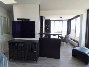 a living room with a flat screen tv on a entertainment center at Penthouse Wohnung direkt am Nodseestrand in Wyk auf Föhr +21 photos