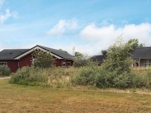 a red house with a field in front of it at 5 star holiday home in Großenbrode in Großenbrode