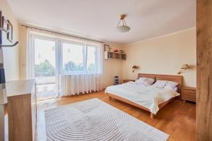 Comfortable holiday home, Swinoujscie في سفينويتشي: غرفة نوم بها سرير ونافذة كبيرة +38 صورة