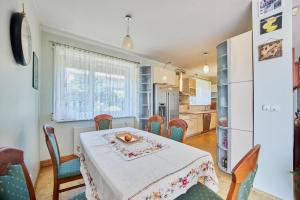 Comfortable holiday home, Swinoujscie في سفينويتشي: مطبخ مع طاولة وكراسي وثلاجة