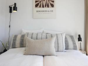 Un dormitorio con una cama blanca con almohadas. en Beautiful holiday home with terrace, en Wissenkerke