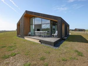 una pequeña casa con terraza en un campo en Beautiful holiday home with terrace, en Wissenkerke