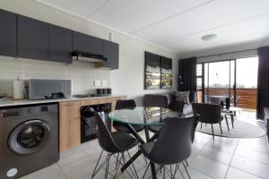 Una cocina y un comedor con mesa y sillas. en #AlimamaSpaces Pano's Greenpark, en Boksburg