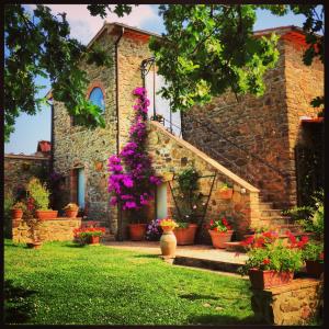 a house with potted plants and flowers in front of it at Casale Giacomini in Manciano