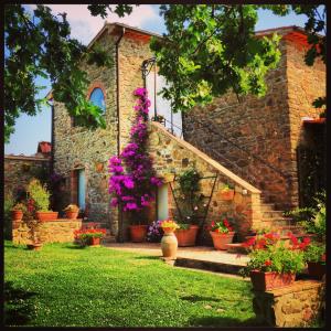 uma casa com vasos de plantas e flores à sua frente em Casale Giacomini em Manciano