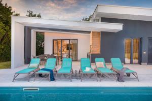 a group of chairs sitting next to a pool at Villa Mariva in Žminj