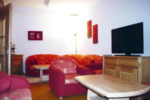 a living room with red furniture and a flat screen tv at holiday home, Fiss in Fiss +4 photos