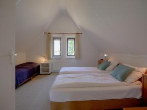 a bedroom with two beds and a window at Spacious 4-person bungalow near the Frisian Lakes in Sondel