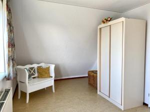 a room with a white cabinet and a chair at comfortable bungalow for 6 people, in Sint Maartenszee +39 photos