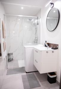 a white bathroom with a shower and a sink at Les Nids Tranquiles - Pays de Fontainebleau in Le Châtelet-en-Brie +20 photos