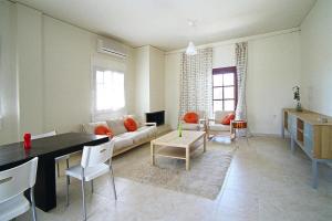 una sala de estar con un sofá y una mesa en Apartment in Residence Rodanthi, en Darmarochori