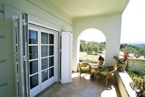 Una puerta abierta a un patio con mesa y sillas. en Apartment in Residence Rodanthi, en Darmarochori