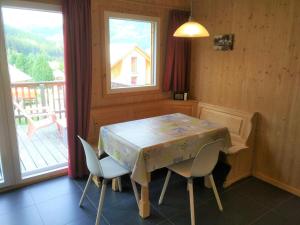 a dining room with a table and chairs and a balcony at Chalet in Hohentauern am Skilift in Hohentauern
