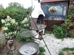 einen Grill in einem Garten mit einem Tisch und einem Schläger in der Unterkunft Topaz, holiday house in Wapnica in Wapnica