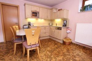 a small kitchen with a table and chairs in it at Ferienanlage Landlust, Muehlental in Oberwürschnitz