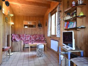 a living room with a red couch and a tv at Chalet in Saulxures near Ski Resorts in Saulxures-sur-Moselotte