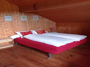 a large bed in a room with wooden walls at Chalet in Saulxures near Ski Resorts in Saulxures-sur-Moselotte