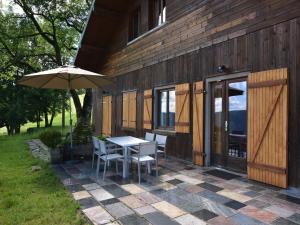 a patio with a table and chairs and an umbrella at Chalet in Saulxures near Ski Resorts in Saulxures-sur-Moselotte