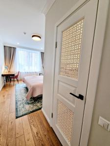 a door leading to a bedroom with a bed at Central Stay Appartments in Šiauliai