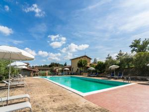 a swimming pool with chairs and umbrellas at Cosy apartment with bubble bath in Perugia