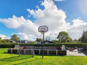 a basketball hoop in a grassy field with a sky at 12 person holiday home in Hadsund-By Traum in Nørre Hurup +19 photos