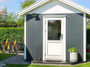 a small shed with a white door and some bikes at 12 person holiday home in Hadsund-By Traum in Nørre Hurup