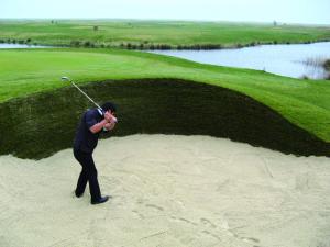 Un hombre balanceando un palo de golf en un campo de golf en Rømø Resort Wellness and Spa, en Sønderby