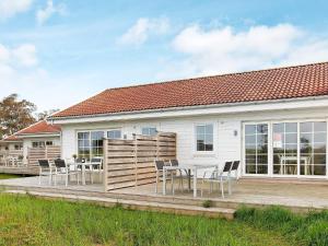 a house with a deck with a table and chairs at Læsø Seaside Holiday Homes in Læsø