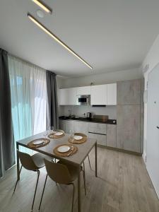 a dining room table with two chairs and a kitchen at Residence Corallina in Caorle