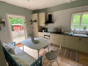 a kitchen with a table and a table and chairs at Torsholma Skolhus in Hallaryd
