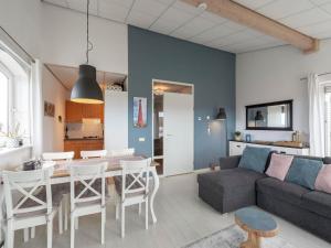 a living room with a couch and a table and chairs at Beachside home with balcony in Julianadorp +104 photos
