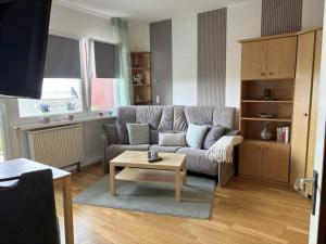 a living room with a couch and a coffee table at Tief 10 mit beheiztem Pool - Meerengel 1001 in Wangerland