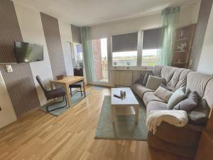 a living room with a couch and a table at Tief 10 mit beheiztem Pool - Meerengel 1001 in Wangerland