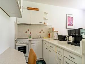 a kitchen with white cabinets and a counter top at Forest Retreat in Jägersgrün in Bad Reiboldsgrün