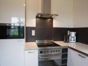 a kitchen with white cabinets and a stove top oven at Mansion in Spa Liege with private garden in Spa