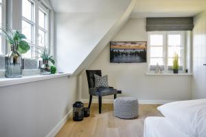 een slaapkamer met een trap met een stoel en een raam bij Haus Dock 10 in Westerland