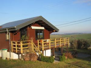 TennevilleにあるQuiet chalet with panoramic view and fenced gardenのポーチとデッキ付きのログキャビン