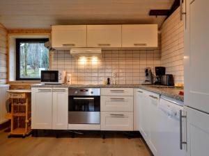 TennevilleにあるQuiet chalet with panoramic view and fenced gardenのキッチン(白いキャビネット、コンロ付)