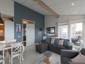 a living room with a couch and a table at Beachside home with balcony in Julianadorp