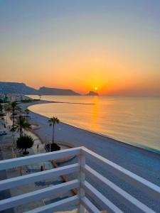 a sunset over the ocean with a white fence at Sunrise Atic Altea Beach by DelucaCo in Altea