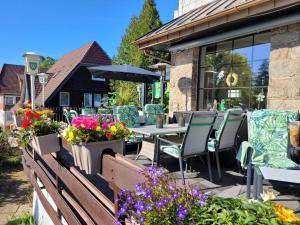a patio with tables and chairs and flowers at Hotel Wappenhof in Braunlage +100 photos