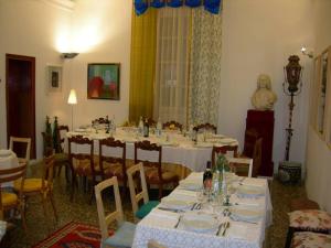 ein Raum mit einem langen Tisch und weißen Tischen und Stühlen in der Unterkunft Hotel Il Falchetto in Pontedera