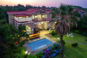 una casa con piscina y una palmera en Jeju Olle House, en Jeju