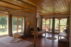 a bedroom with a bed and a room with windows at Lharimo North Cottages - Nubra Valley in Wāhegaon +74 photos