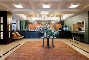 a lobby with a table with flowers on it at Best Western Plus Atakent Park Hotel in Almaty