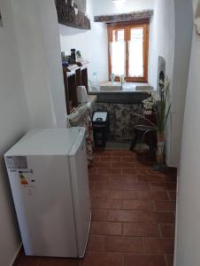 a kitchen with a white refrigerator and a sink at Rooms Poli Luce - Room Zvane in Gračišće