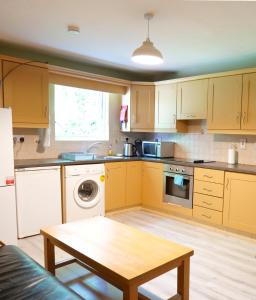 a kitchen with yellow cabinets and a table in it at Heartbeat Cottage in Letterkenny