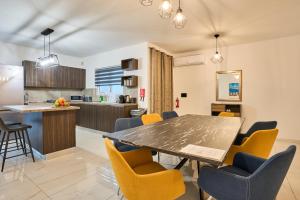a dining room and kitchen with a table and chairs at Il-Girna- Modern Seaside Accommodation in Marsaskala